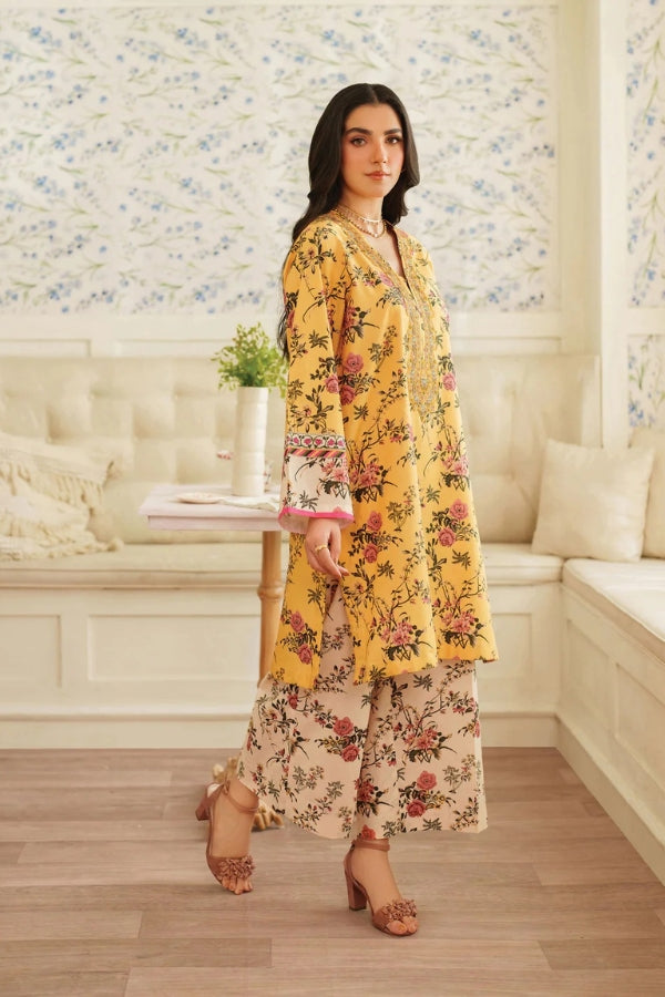 Woman in a yellow floral outfit standing in a room with floral wallpaper.