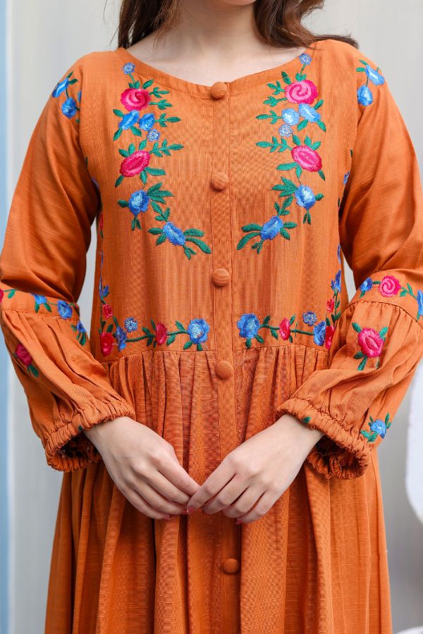 Orange dress with floral embroidery on a plain background
