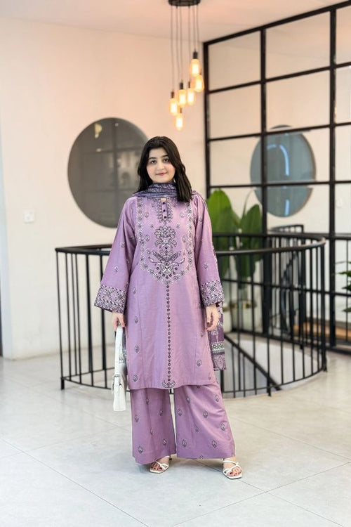 Woman wearing a lavender traditional outfit in an indoor setting with modern decor.