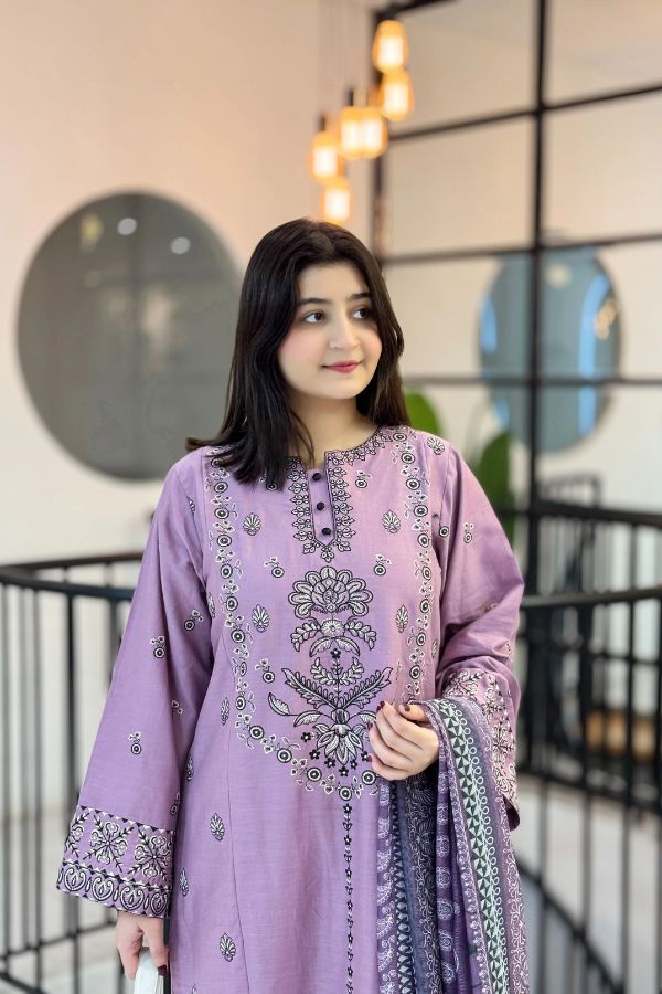 Woman wearing a purple embroidered outfit with a matching dupatta in an indoor setting.