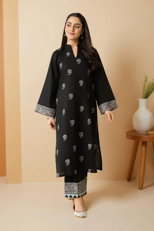 Woman wearing a black traditional outfit with white patterns on a beige background