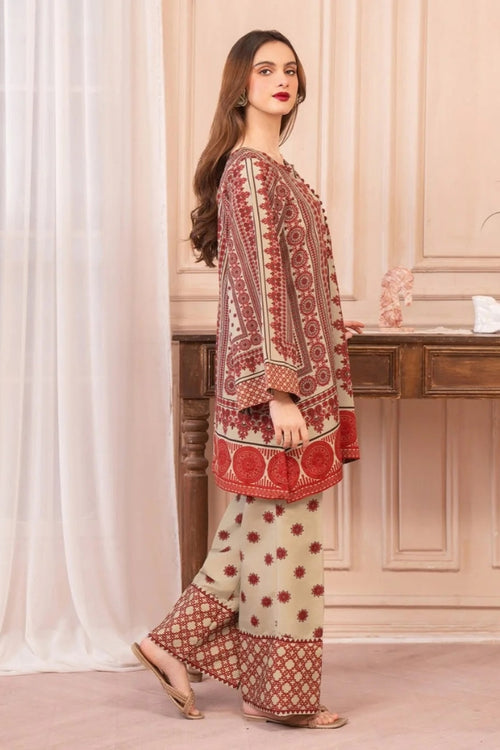 Woman wearing a traditional outfit with red and beige patterns in a room.