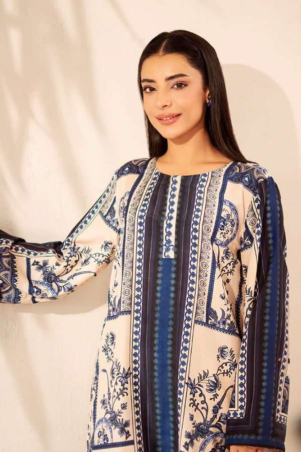 Woman wearing a blue and white patterned outfit against a plain background