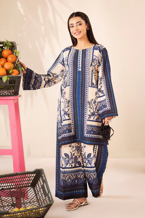 Woman wearing a blue and white patterned outfit holding a basket of oranges.