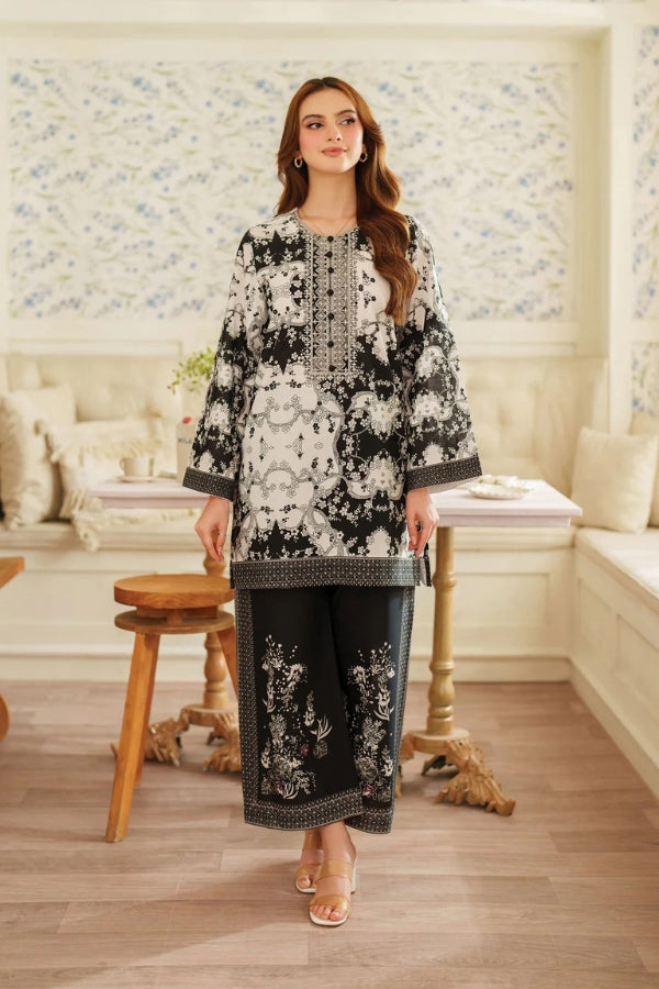 Woman wearing a black and white floral outfit in a decorated room.