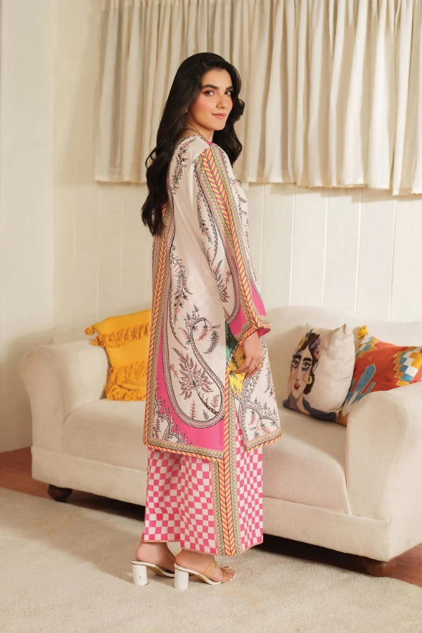 Woman in a traditional outfit standing in a living room with a couch and pillows.
