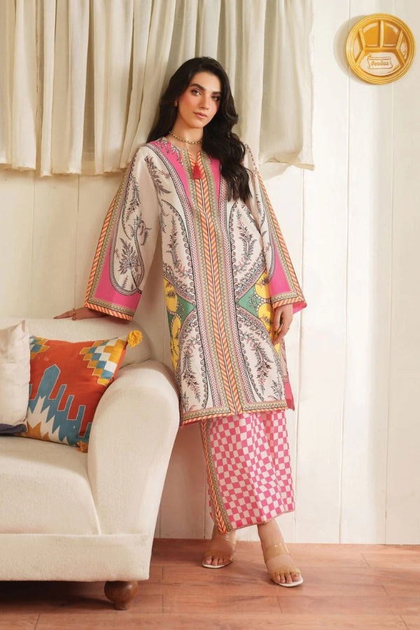 Woman in a patterned outfit sitting on a couch with a colorful pillow.