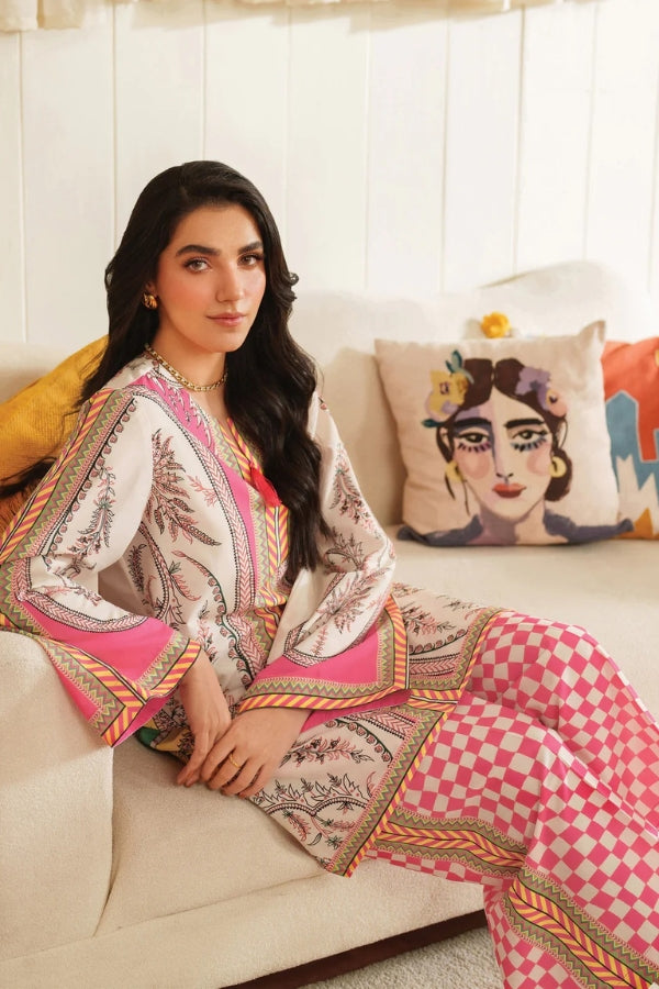 Woman in a patterned outfit sitting on a couch with colorful pillows.