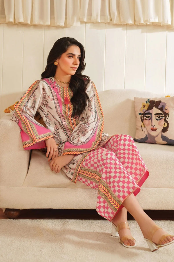 Woman in a patterned outfit sitting on a couch with a decorative pillow.