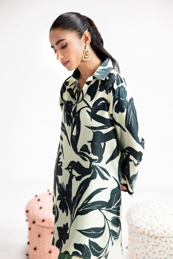 Woman wearing a black and white floral dress with a plain background