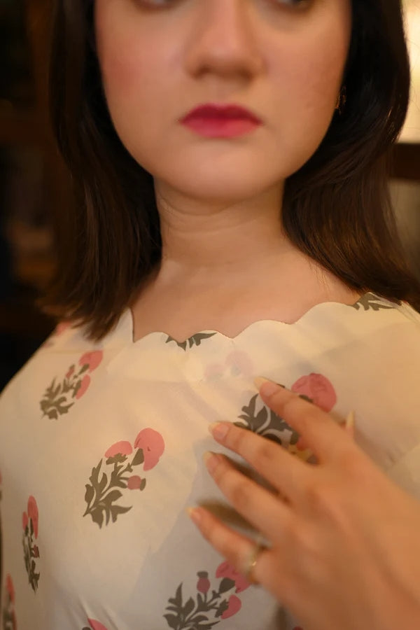 Close-up of a person wearing a floral blouse with a blurred background