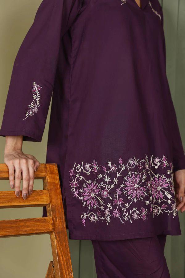 Purple embroidered outfit on a chair against a plain background