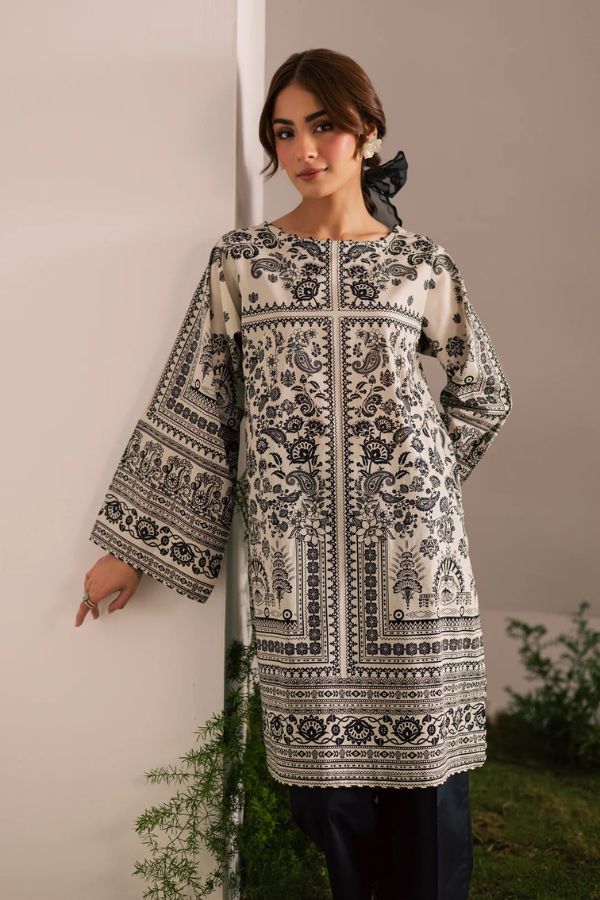 Woman wearing a black and white patterned dress against a neutral background