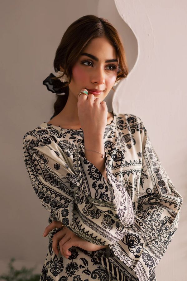 Woman wearing a black and white patterned outfit against a plain background