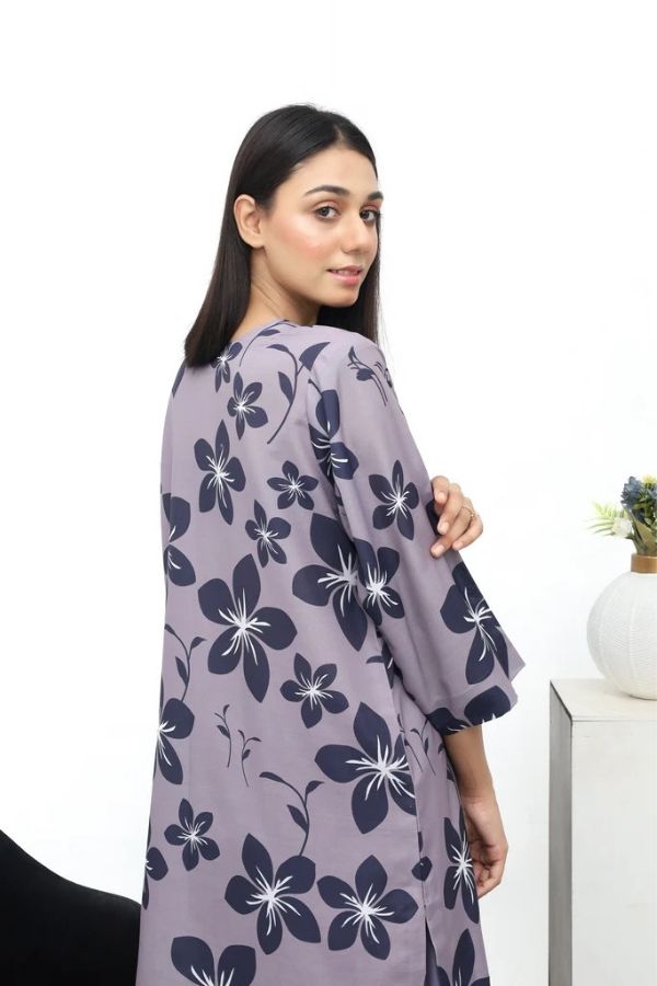 Woman wearing a gray floral dress against a white background