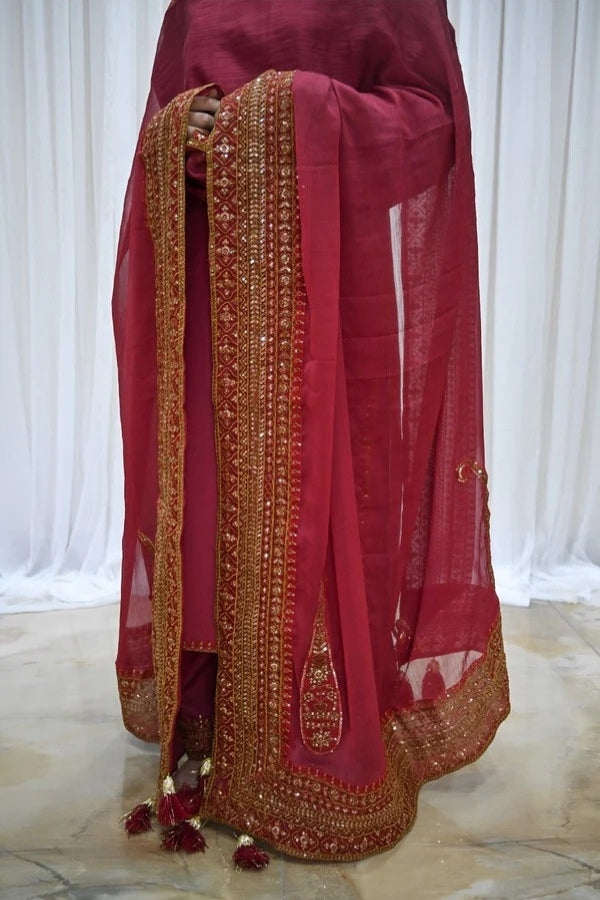 Premium maroon 3-piece festive stitched suit for women – featuring golden hand embroidery, gota work, mirror embellishments, and an embroidered chiffon dupatta with tassels – traditional Pakistani outfit perfect for Eid, mehndi, and formal events.