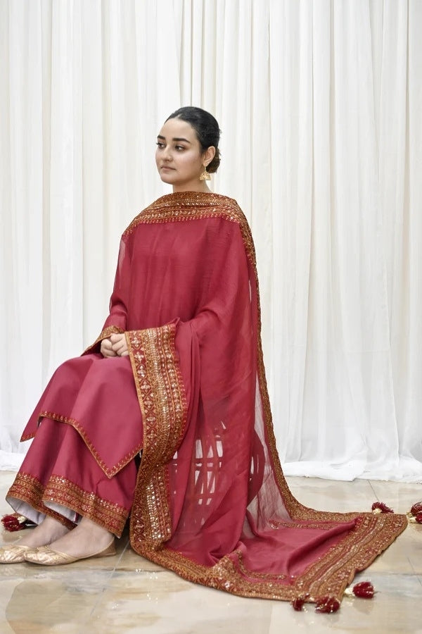 Premium maroon 3-piece festive stitched suit for women – featuring golden hand embroidery, gota work, mirror embellishments, and an embroidered chiffon dupatta with tassels – traditional Pakistani outfit perfect for Eid, mehndi, and formal events.