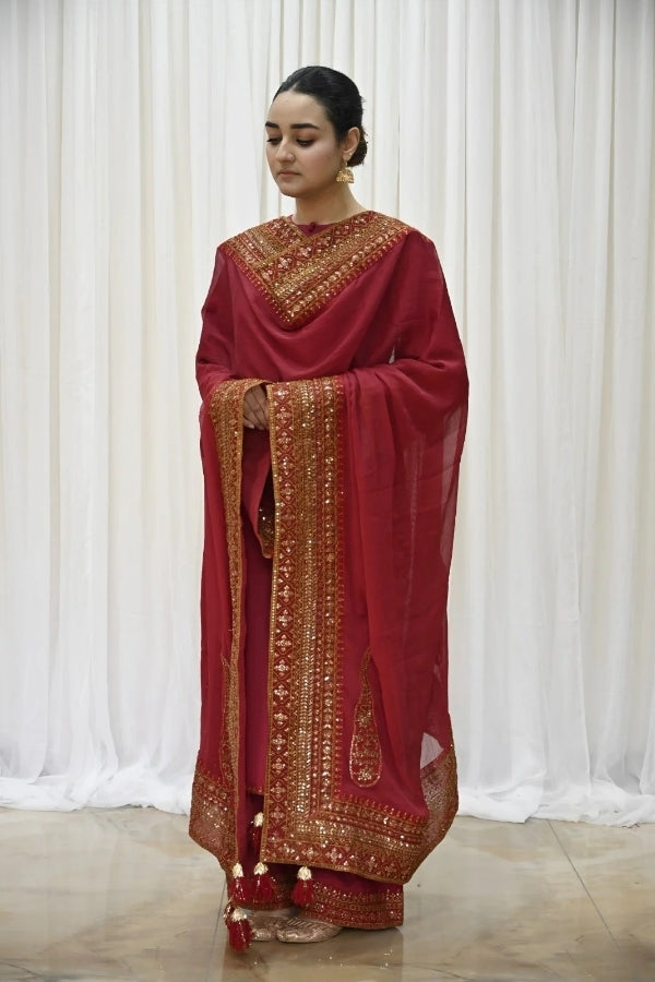 Premium maroon 3-piece festive stitched suit for women – featuring golden hand embroidery, gota work, mirror embellishments, and an embroidered chiffon dupatta with tassels – traditional Pakistani outfit perfect for Eid, mehndi, and formal events.