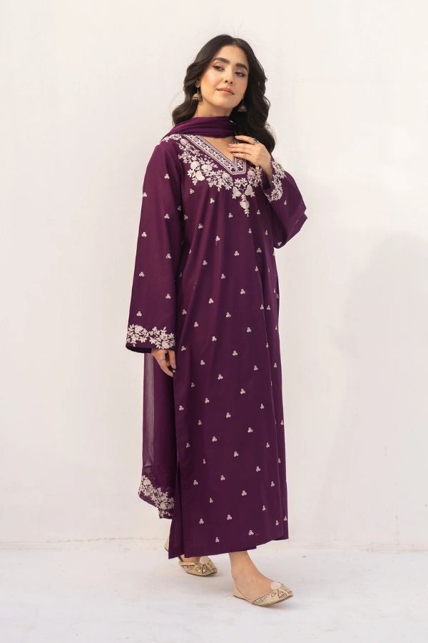 Woman wearing a purple dress with white embroidery on a white background