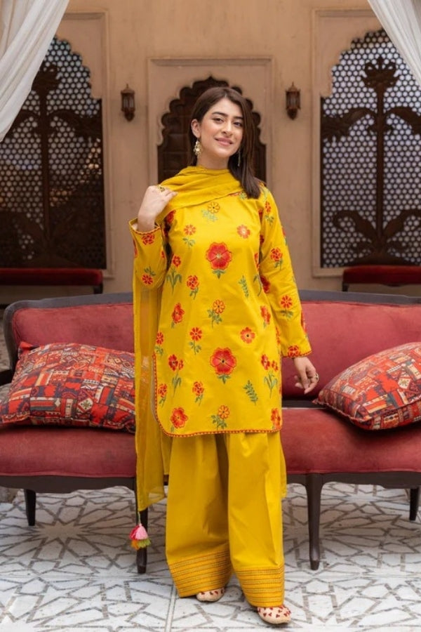 Premium mustard lawn suit by Ragini featuring delicate floral embroidery, embroidered lawn shirt, dyed trousers, and flowing Bamber chiffon dupatta – perfect summer outfit for women in Pakistan, ideal for festive and semi-formal wear.
