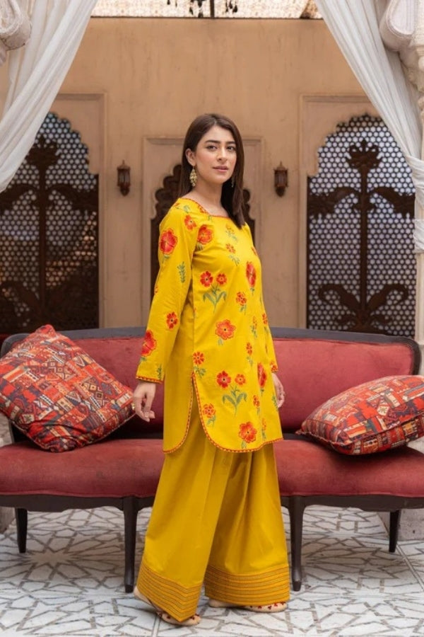 Premium mustard lawn suit by Ragini featuring delicate floral embroidery, embroidered lawn shirt, dyed trousers, and flowing Bamber chiffon dupatta – perfect summer outfit for women in Pakistan, ideal for festive and semi-formal wear.