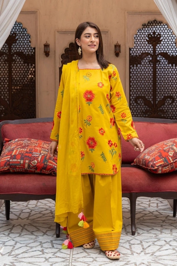 Premium mustard lawn suit by Ragini featuring delicate floral embroidery, embroidered lawn shirt, dyed trousers, and flowing Bamber chiffon dupatta – perfect summer outfit for women in Pakistan, ideal for festive and semi-formal wear.