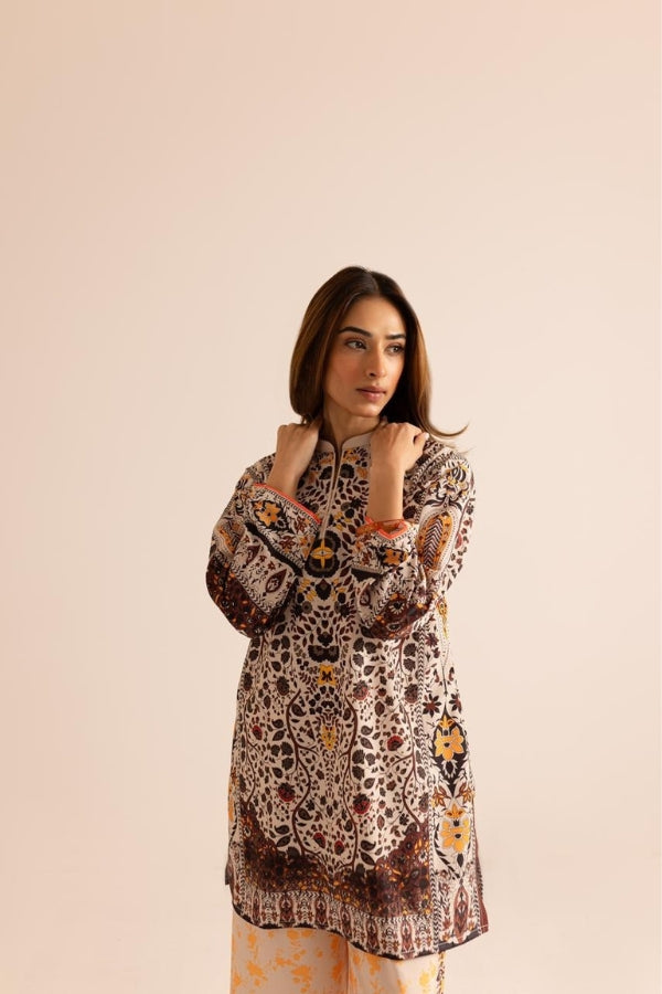 Woman wearing a patterned kurta with a plain background