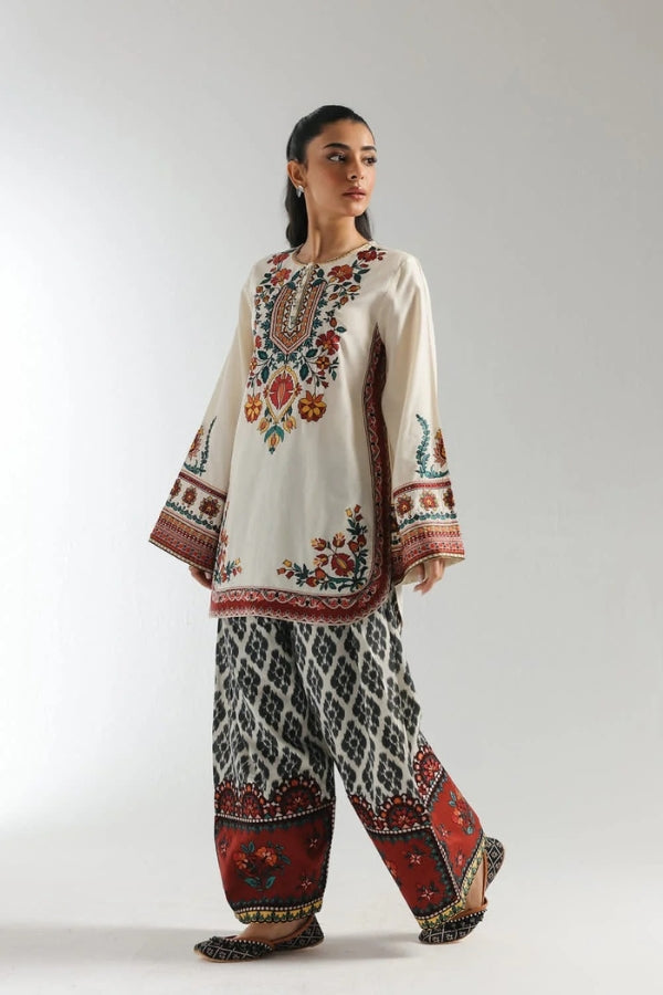 Woman wearing a traditional embroidered outfit with a white background