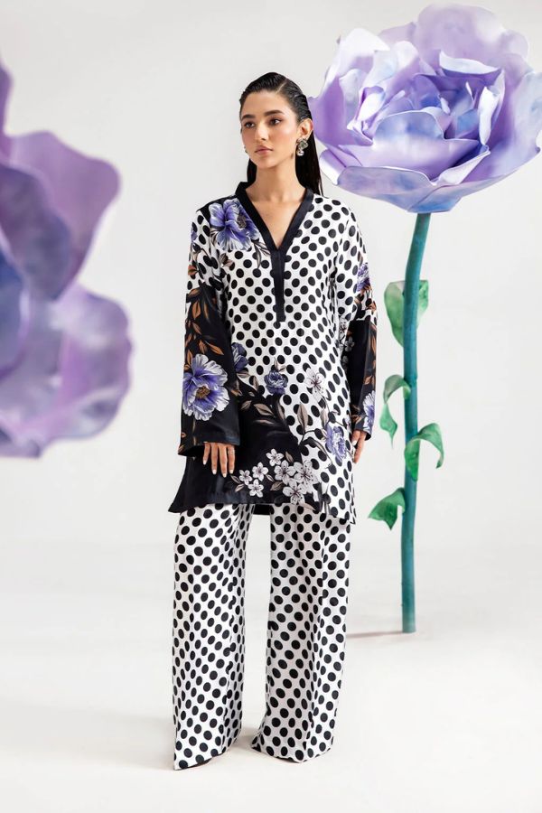 Woman in a polka dot outfit with large purple flowers on a white background