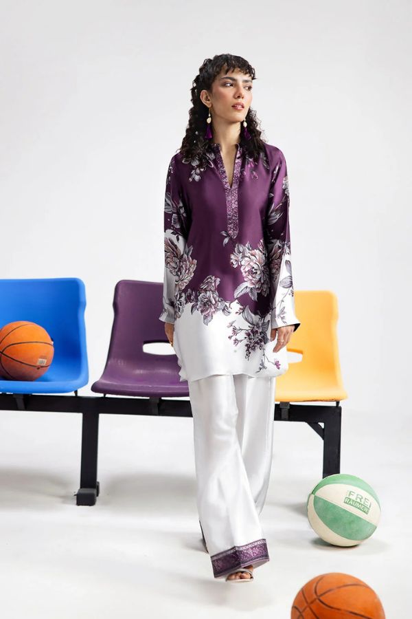 Woman in a purple floral top and white pants standing next to sports balls on a white background