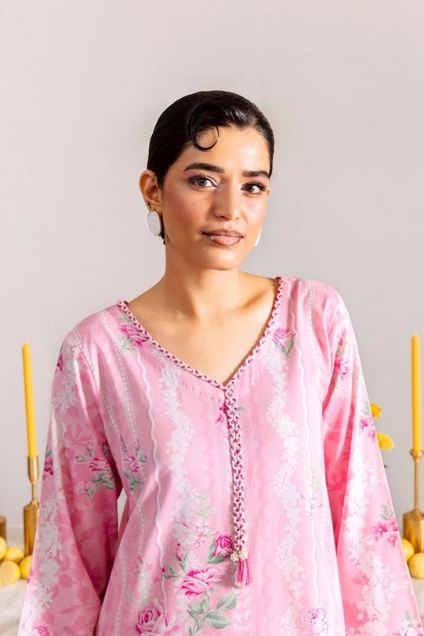 Woman wearing a pink floral dress against a neutral background
