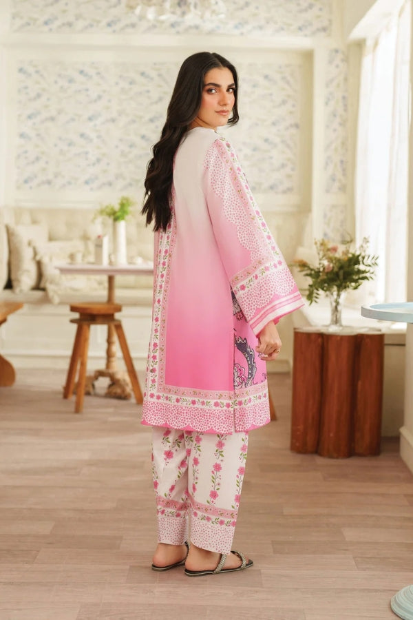 Woman wearing a pink and white traditional outfit in a room with wooden furniture and decorative elements.