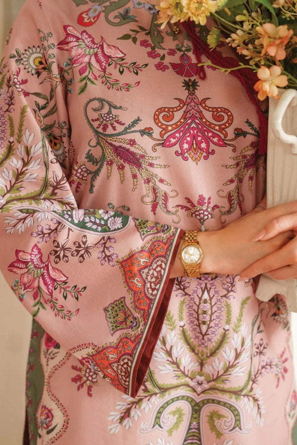 Person wearing a pink patterned garment with a floral arrangement in the background