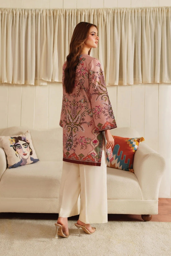 Woman wearing a floral kimono-style outfit in a living room setting.