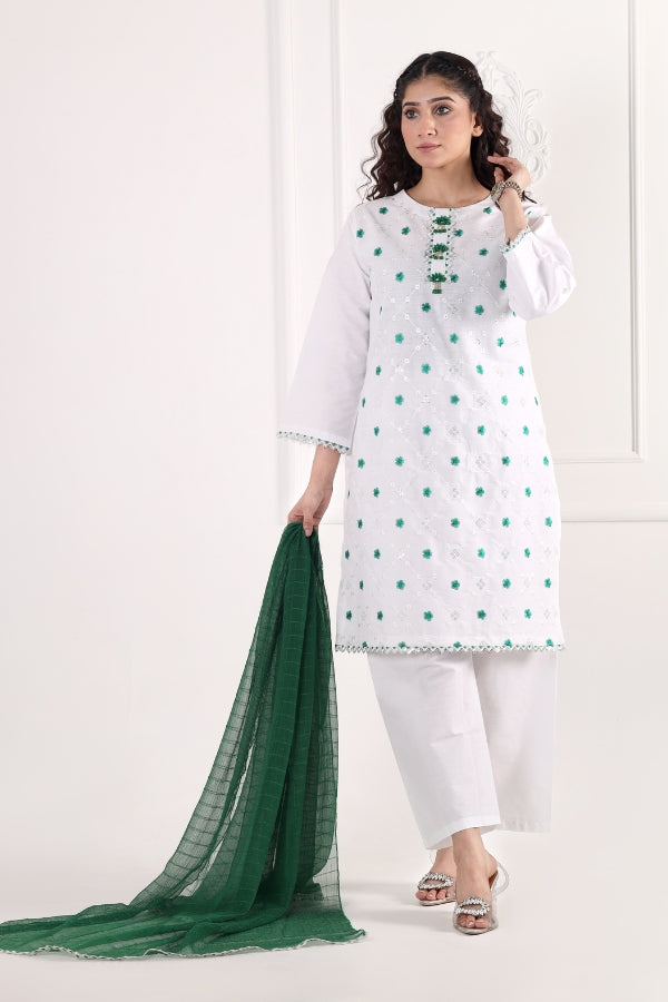 Woman wearing a white kurta with green polka dots and white pants, holding a green scarf on a white background.