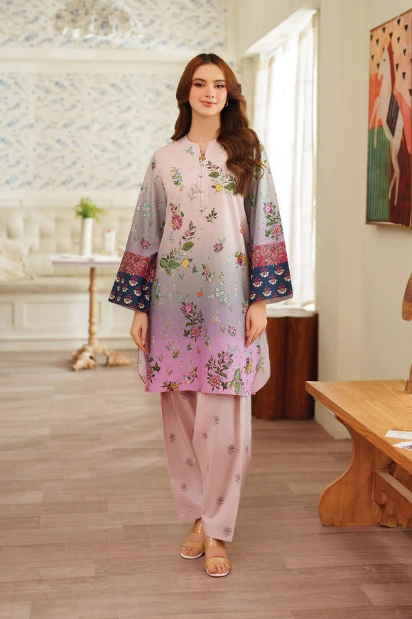 Woman in a floral dress standing in a room with wooden flooring and a painting on the wall.