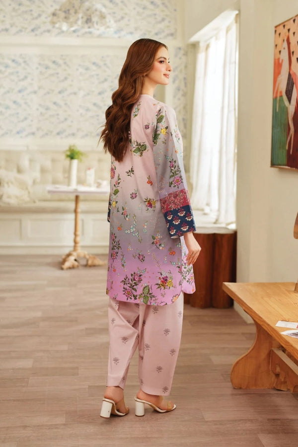 Woman wearing a floral outfit in a room with wooden flooring and a painting on the wall.