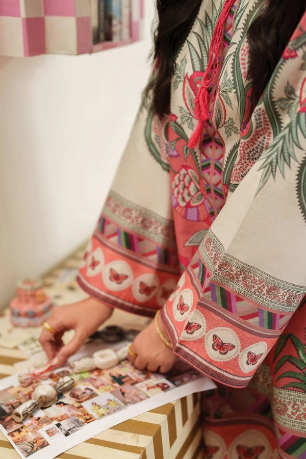 Person wearing a colorful traditional outfit with butterfly patterns, sitting on a couch.