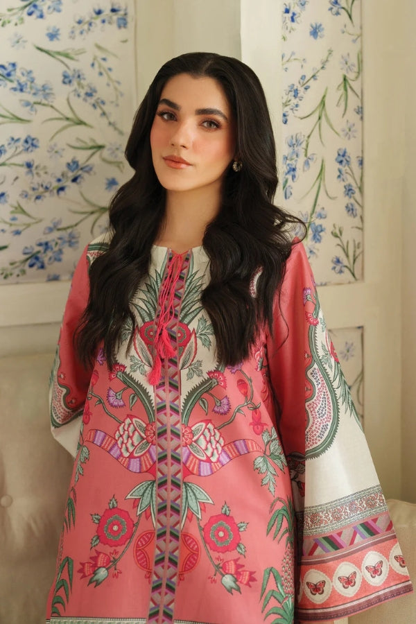 Woman wearing a pink embroidered dress with a floral wall in the background