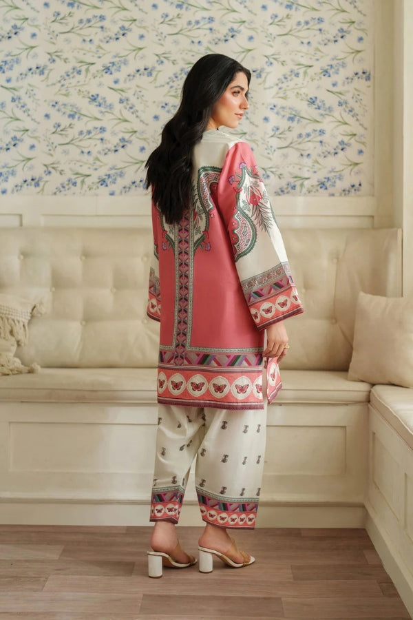 Woman wearing a traditional outfit with a floral pattern in a room with floral wallpaper.