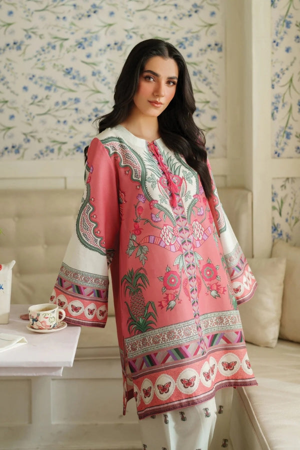 Woman wearing a pink embroidered dress in a decorated room.