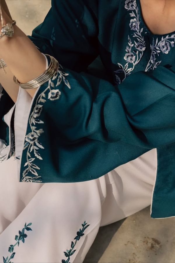 Teal and white embroidered outfit with floral patterns