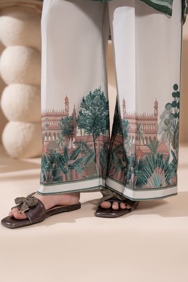 White pants with a scenic print worn by a person, standing on a light background.