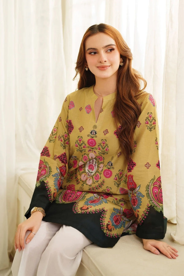 Woman wearing a yellow Printing traditional outfit sitting on a white couch.