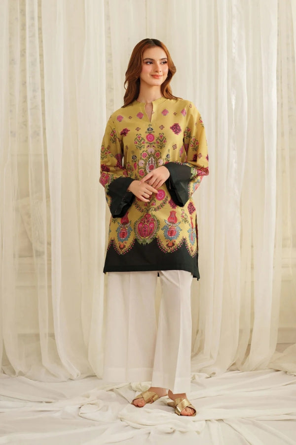Woman wearing a traditional Printing outfit with a black and yellow top and white pants against a white curtain background.